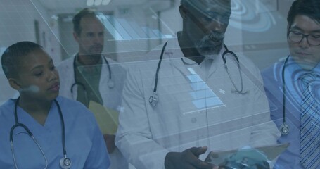 Standing medical team studying tablet with stethoscopes in hospital corridor under digital overlay