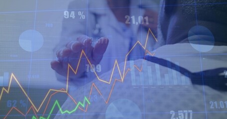 Two colleagues in business attire reviewing financial data in meeting room, with overlay and laptop