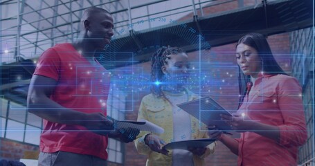 Three coworkers reviewing papers, tablet and holographic interface in workshop, with vehicle hood