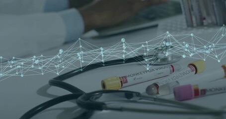 Showing capped MONKEYPOX VIRUS vials in lab, stethoscope, digital overlay, scientist typing laptop