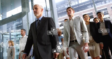 Striding grey-haired leader guiding team in suits through glass atrium with social media overlays