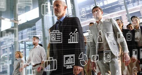 Male executive leading team in glass-walled atrium with steel supports, displaying digital icons