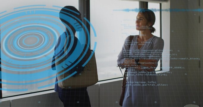 Standing colleagues in scrubs and dress observing code overlay at office with stethoscope and bags
