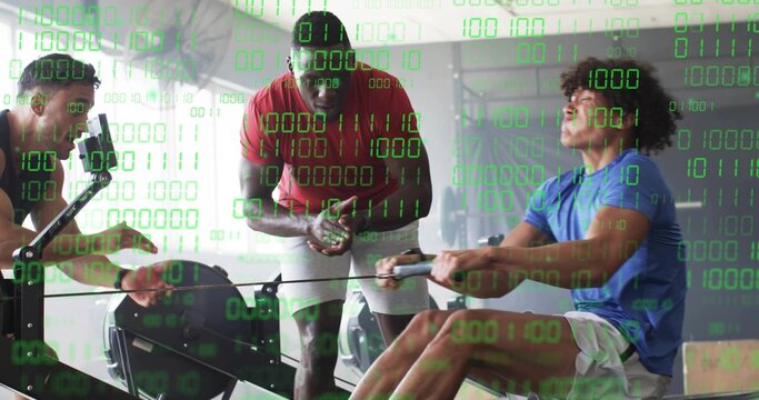 Trainer in red shirt guiding two clients rowing on machines in gym with binary overlay