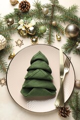 Festive table setting with Christmas decor on beige background, flat lay