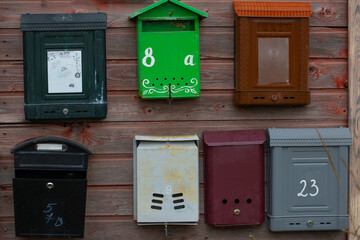 A rusty wall on the street with old metal mailboxes