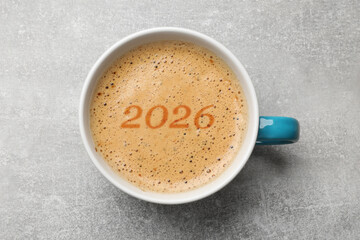Hello New 2026 Year. Cup of coffee with numbers on grey table, top view