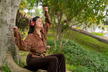 Young woman enjoying music relaxing in nature