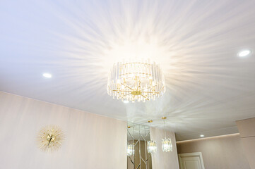 Elegant interior featuring a crystal chandelier, ambient lighting, and a gold decorative clock, showcasing a sophisticated and stylish aesthetic