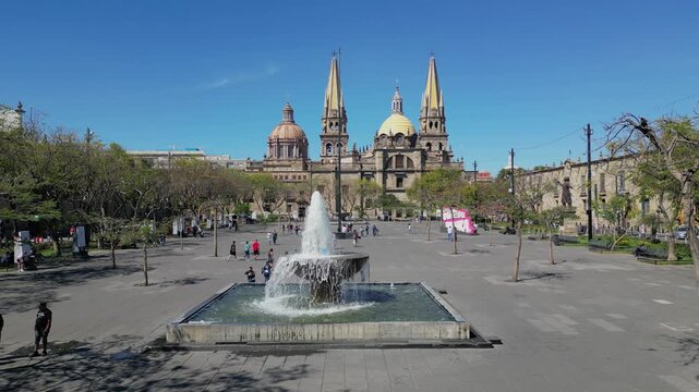 Stationary shot of the main fountain in Plaza Tapatia, Guadalajara, with the iconic cathedral behind