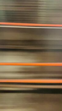 Vertical view from a metro train window showing underground tunnels in motion. Urban transportation scene illustrating daily commuting and city infrastructure.