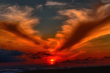 Fototapeta premium Sunset sky with angel-shaped clouds illuminating the horizon