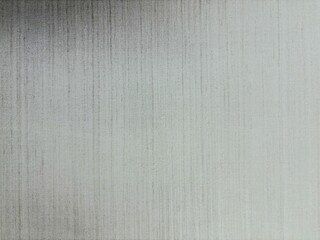 A detailed macro shot of a brushed metal texture with a vertical hairline finish, showing a subtle gradient from dark to light gray, suitable for modern, industrial, and minimalist design backgrounds.