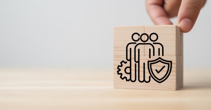 Teamwork and Security: A hand places a block with a team symbol and a shield, symbolizing teamwork, safety and security, highlighting the importance of protection and collaborative effort. 