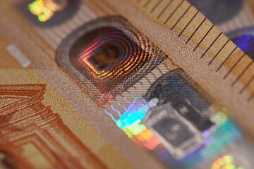 Macro shot of a holographic security detail on a 50 euro note, showcasing vibrant colors and...