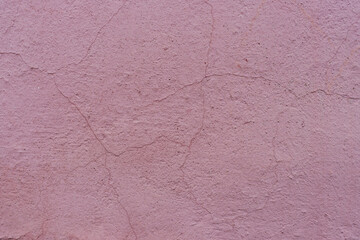 Backdrop of a cracked pink wall.
