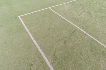Artificial green turf with white painted lines on a open sports field