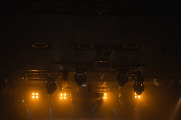 Dim, moody backstage scene with warm amber stage lights