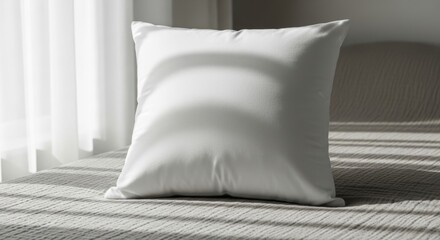 Elegant white pillow resting on a textured bed with window light stripes