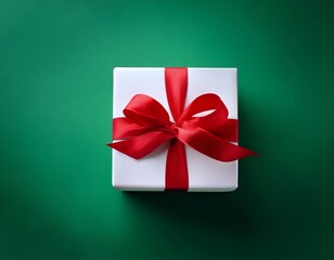 white gift box with red ribbon on green background