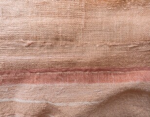 close up of a textured fabric with light beige burlap and horizontal streaks of a pinkish tan color