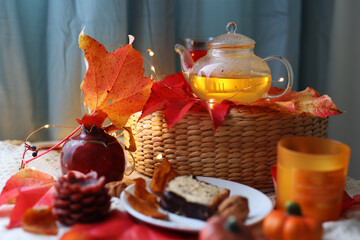 Cozy autumn tea setup with candles, cake, and warm seasonal leaves. Perfect fall hygge mood.
