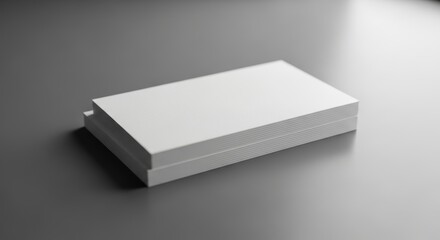 Stack of crisp white business cards on a sleek gray surface close up