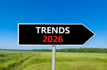 Trends 2026 new year symbol. Concept words Trends 2026 on beautiful black road sign. Beautiful green grass field forest and blue sky background. Business and Trends 2026 new year concept. Copy space.
