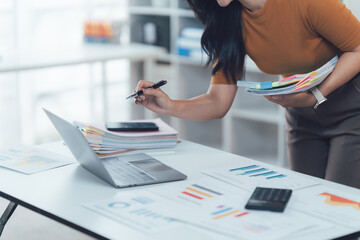 Analyst at Work: A diligent professional delves into the intricate details of data analysis, employing tools such as a laptop, calculator.