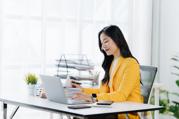 Businesswoman at Work: A poised businesswoman, clad in a vibrant yellow jacket, engages in focused...