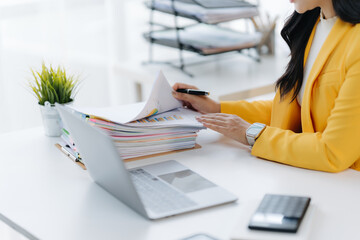 Busy at Work: Focused on the details, a business person meticulously reviews documents at a neat...