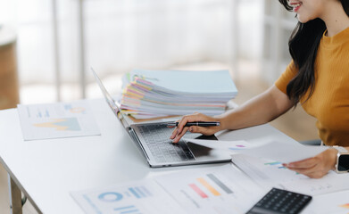 Busy Workday: A professional woman focused on work, managing tasks, documents, and data with diligence, showing modern office atmosphere.