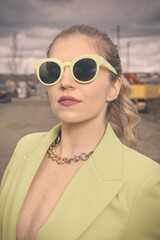 Pretty lady in green costume posing on industrial location