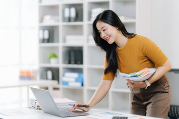 Creative Professional at Work: An intelligent designer is engrossed in her work, surrounded by vibrant swatches and a modern laptop, showcasing creativity and professional focus.