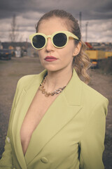 Pretty lady in green costume posing on industrial location