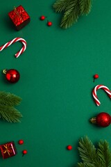 A festive Christmas flat lay with decorations on a dark green background. View from above, vertical...