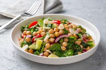 Vegetarian chickpea salad with tomatoes, arugula, parsley, spinach and red onion. Healthy food, diet. Top view