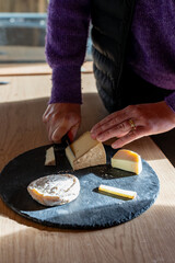 Gros plan sur la découpe des fromages produits à la ferme, mettant en avant la texture artisanale, la fraîcheur des produits et le savoir-faire traditionnel.
