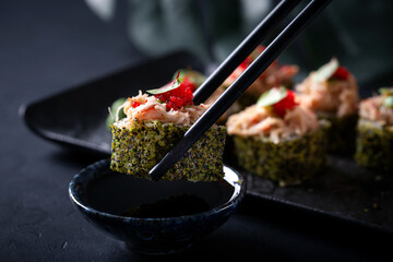 Japanese cuisine. Sushi rolls on a black platter