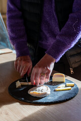 Gros plan sur la découpe des fromages produits à la ferme, mettant en avant la texture artisanale, la fraîcheur des produits et le savoir-faire traditionnel.