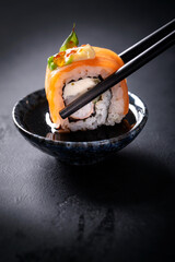 Japanese cuisine. Sushi rolls on a black platter