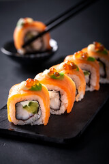 Japanese cuisine. Sushi rolls on a black platter