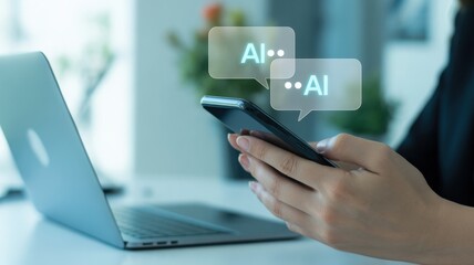 A person's hands using a mobile phone to communicate about AI with a laptop in the background.