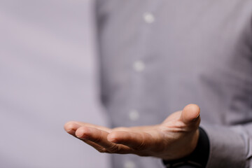 Close-up of a man's open hand, palm facing upwards. The image conveys concepts of giving, receiving, support, and offering. A simple, minimalist