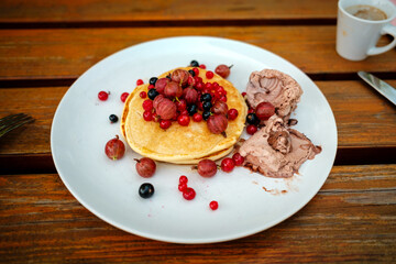 Pancakes mit Beeren und Eiscreme am Teller