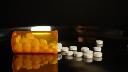 Medications pills and drugs spilled out of container. Pharmaceutical Industry. Modern drug and pharmacy, addiction, slow motion. White narcotic painkillers represent the opioid crisis in America.