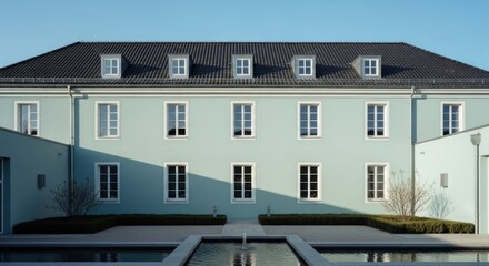 Fototapeta premium Elegant mint facade building, white windows, dark roof, modern fountain courtyard garden