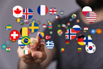 A hand touching various international flags representing global communication, travel, and cultural diversity. This image highlights themes of i