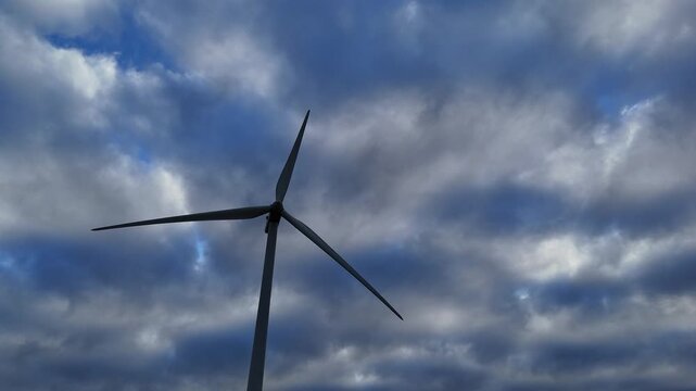 &eacute;olienne qui tourne,  prise &agrave; contre-jour en fin de journ&eacute;e sur un ciel tr&egrave;s nuageux