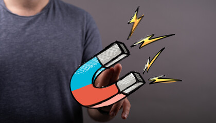 Hand holding a strong magnet, attracting, energy, power, success, business, marketing, growth,...